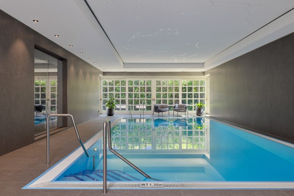 Hotel-Innenpool mit gläserner Front, eleganter Decke mit Sternenmuster und Sitzbereich