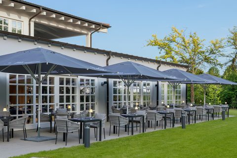 Reihen von Tischen und Sonnenschirmen auf Terrasse vor dem Restaurant in Affalterbach