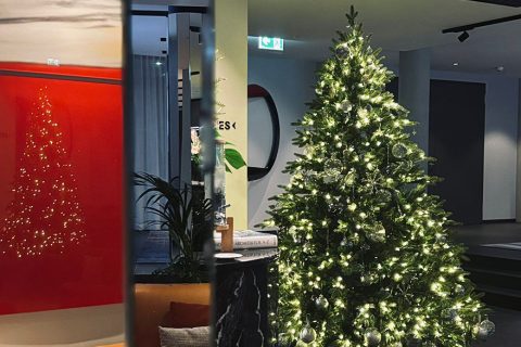 Weihnachtsbaum erleuchtet moderne Lobby, Spiegelwand reflektiert Licht