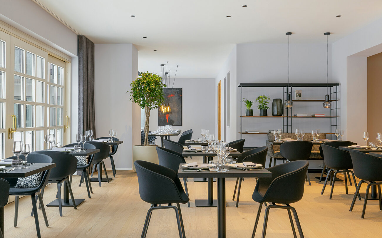 Gedeckte Tische in hellem, modernem Restaurant in Affalterbach mit schwarzen Stühlen