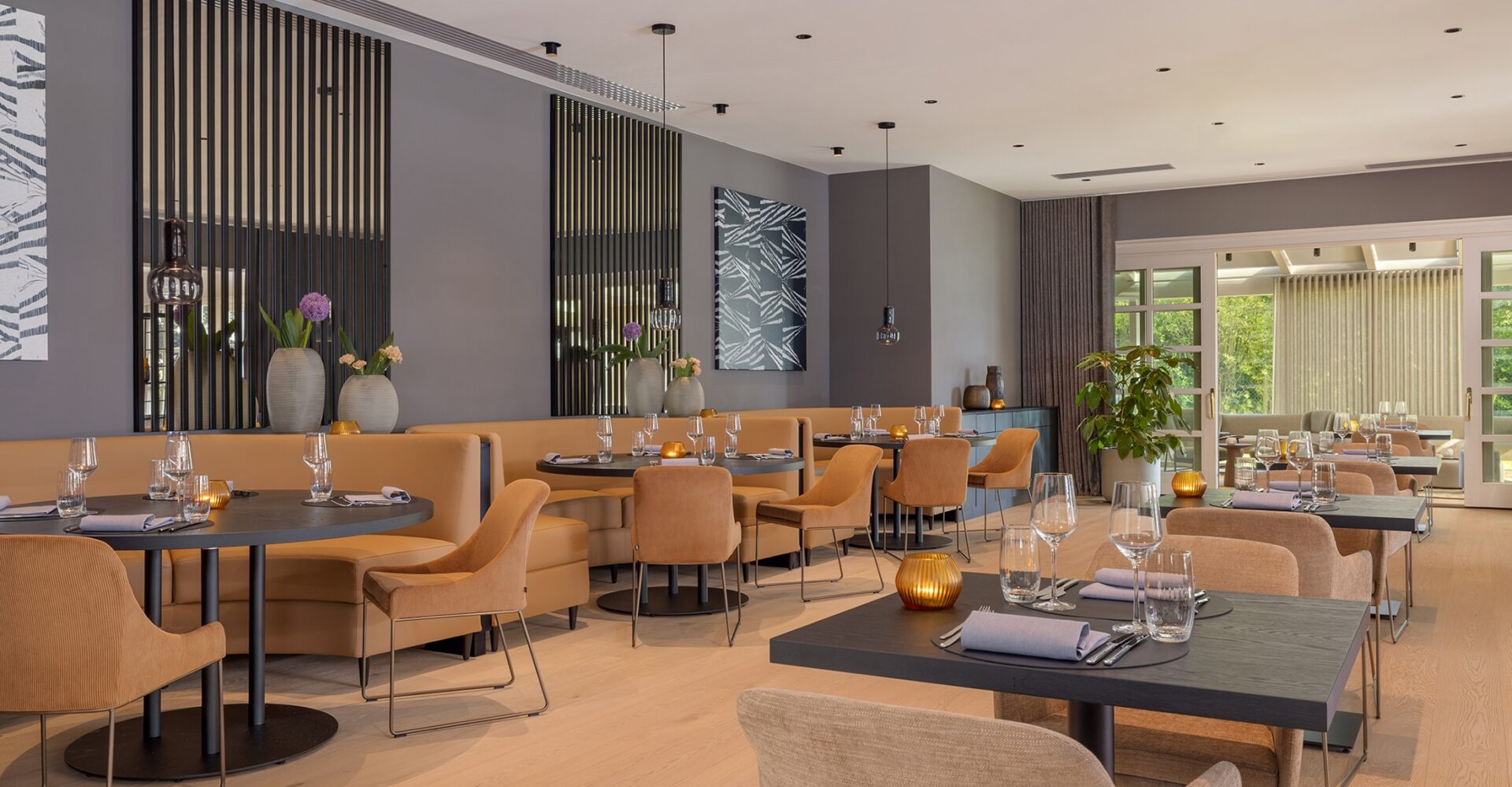 Gedeckte Tische in modernem Restaurant nahe AMG Mercedes, Sitzbänke und Fensterblick