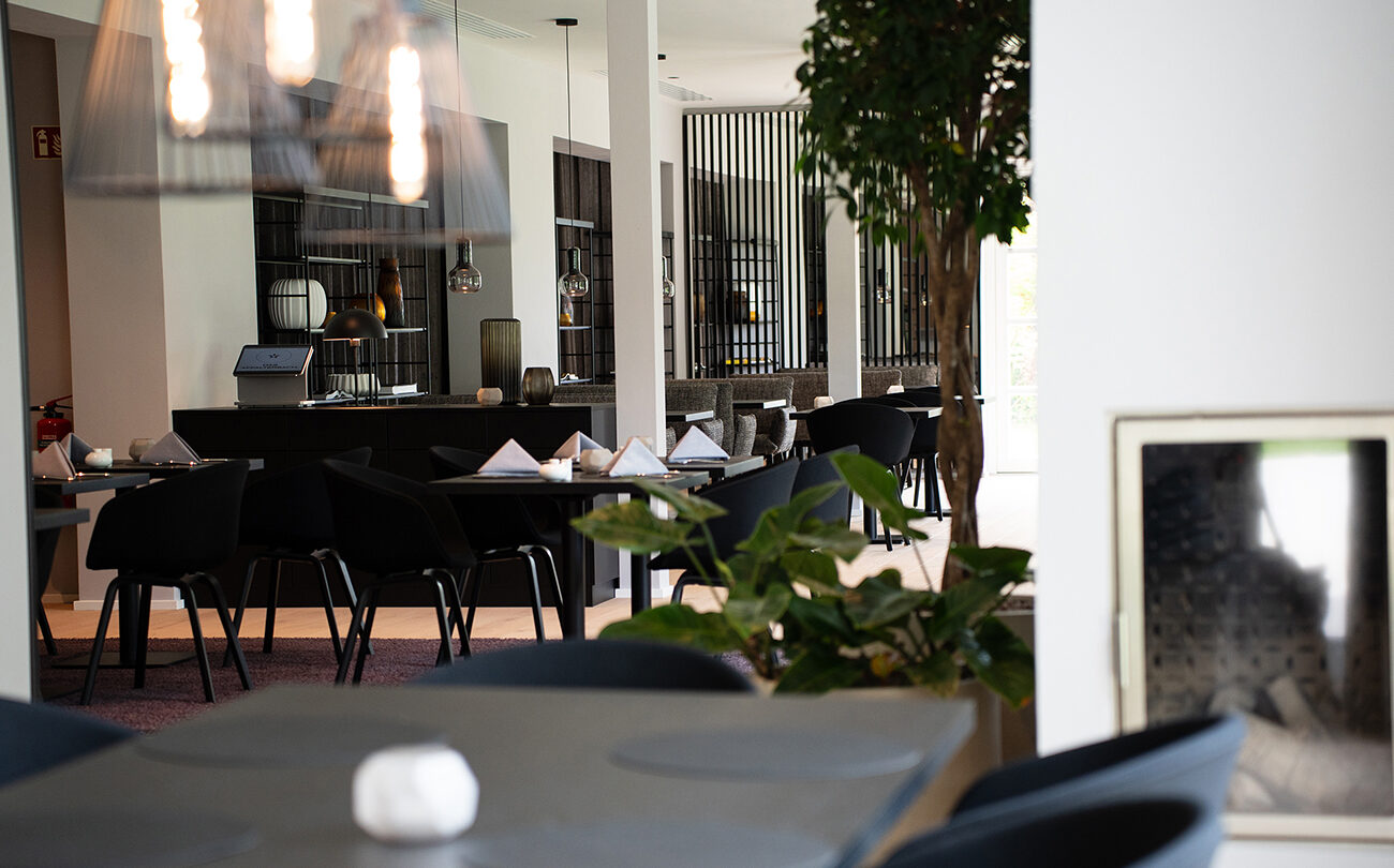 Gedeckte Tische stehen in modernem Restaurant in der nähe von Stuttgart, Pflanzen im Vordergrund