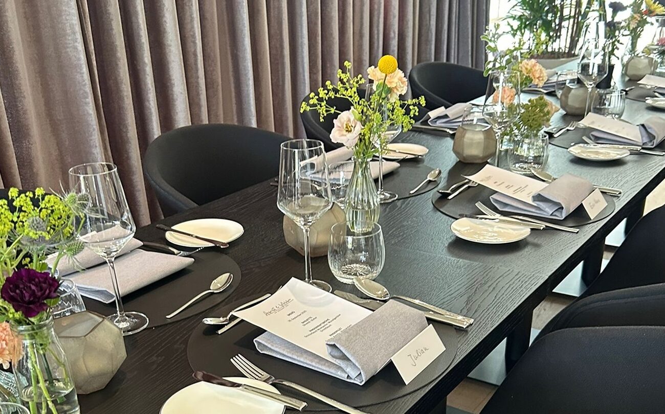 Gedeckter Tisch mit Blumen und Karten vor Vorhang im Hotel nahe Stuttgart