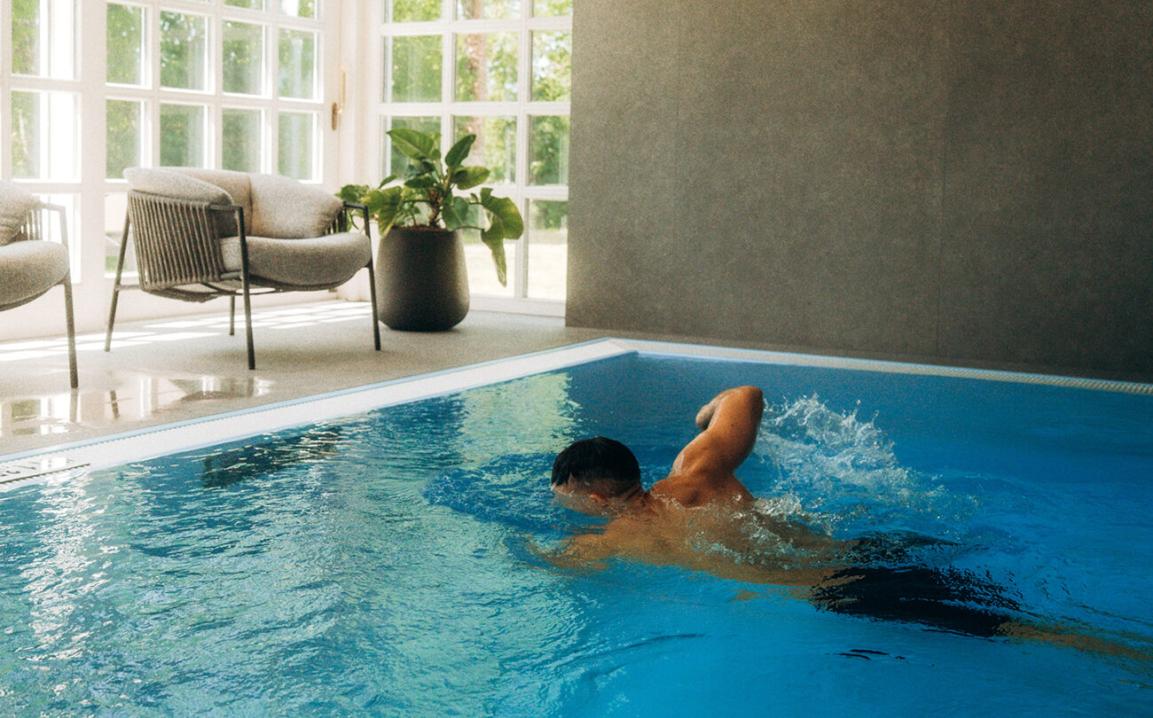Mann beim Kraulen im Hallenbad des Hotels nahe Stuttgart